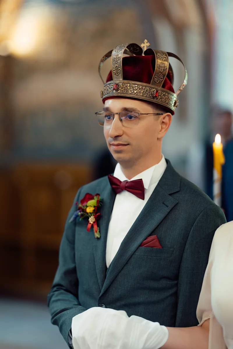 Portrait of a groom wearing a jeweled ceremonial crown, glasses and a burgundy bow tie
